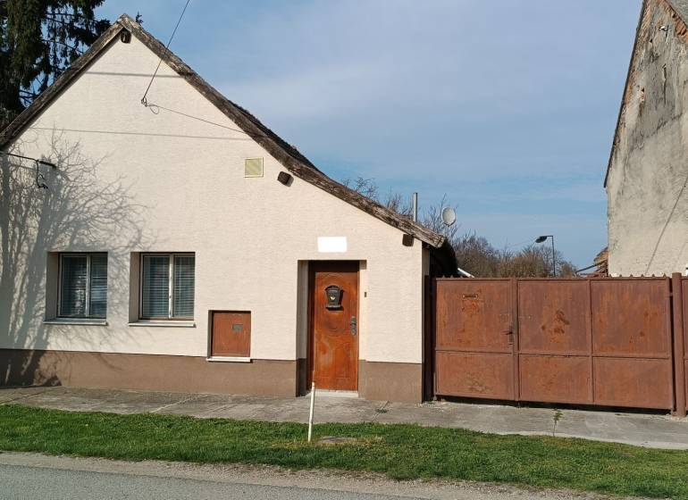 Na predaj RD na bývanie alebo investičná príležitosť Horné Saliby - Rodinný dom na Salibskej ulici v Horných Salibách s jednoduchou fasádou a kovovou bránou.