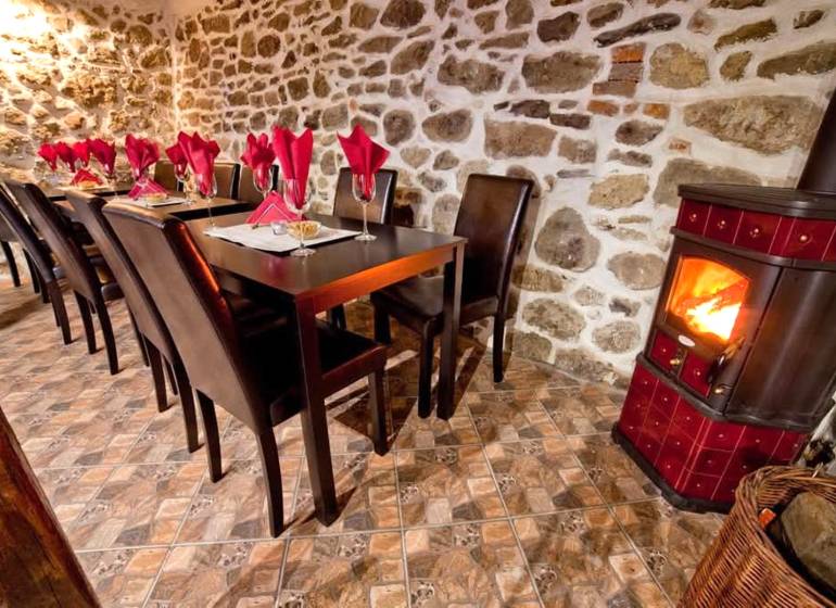 Prenájom gastro priestoru v centre Krupiny - Rustikálne gastro priestory s krbom, kamennou stenou a stolmi so servítkami.