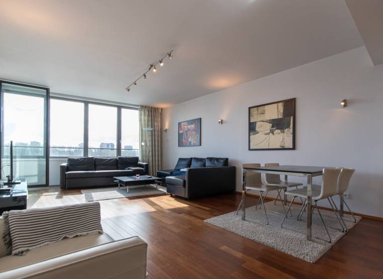 Moderný 2-izbový byt s balkónom, Eurovea - Obývačka s veľkými oknami, podlaha s dreveným dekorom, pohodlný nábytok a jedálenský kút.