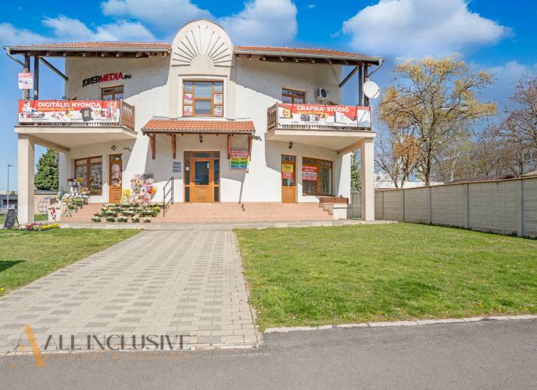 NA PRENÁJOM OBCHODNÝ PRIESTOR-KANCELÁRIA ,DUN. STREDA - Na ulici Jilemnického budova s reklamou a kvetinovou dekoráciou pred kanceláriou.