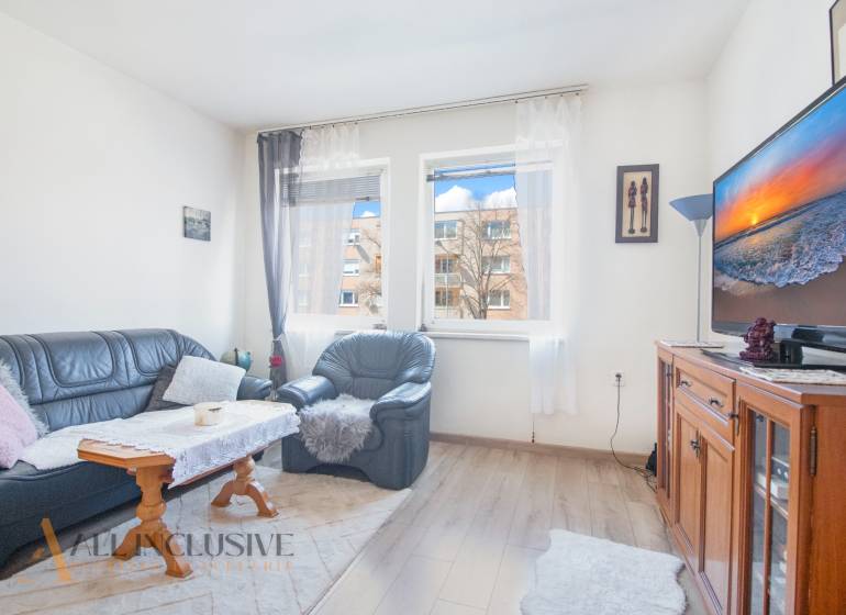 NA PREDAJ 2-IZBOVÝ BYT V CENTRE MESTA DUNAJSKÁ STREDA - Obývacia izba s koženou sedacou súpravou, televízorom a výhľadom na ulici Biskupa Kondého, ponuka 2-izbového bytu.