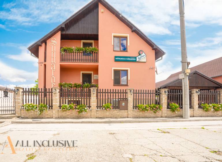 NA PREDAJ PENZIÓN VO VEĽKOM MEDERI – SUNGARDEN - Penzión s dreveným plotom a kvetinovou výzdobou v meste Veľký Meder.