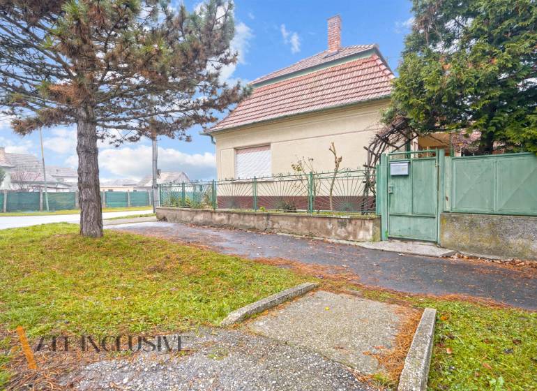 REZERVOVANÉ 4-IZBOVÝ RODINNÝ DOM, TOPOĽNÍKY - Rodinný dom v Topoľníkoch s veľkým stromom a kovovým plotom.