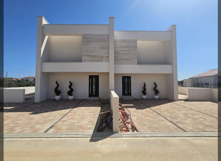 VRSI - dvojdom s bazénom a záhradou - Rodinný dom na ulici Mulo vo Vrsi s dlaždeným chodníkom a dekoratívnymi rastlinami.