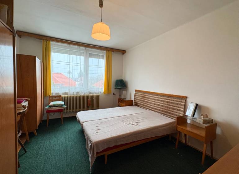 Exkluzívny PREDAJ 4 izbového rodinný domu s garážou, Zlatná na Ostrove - Spálňa s jednoduchým nábytkom v rodinnom dome, zelený koberec a žlté záclony.