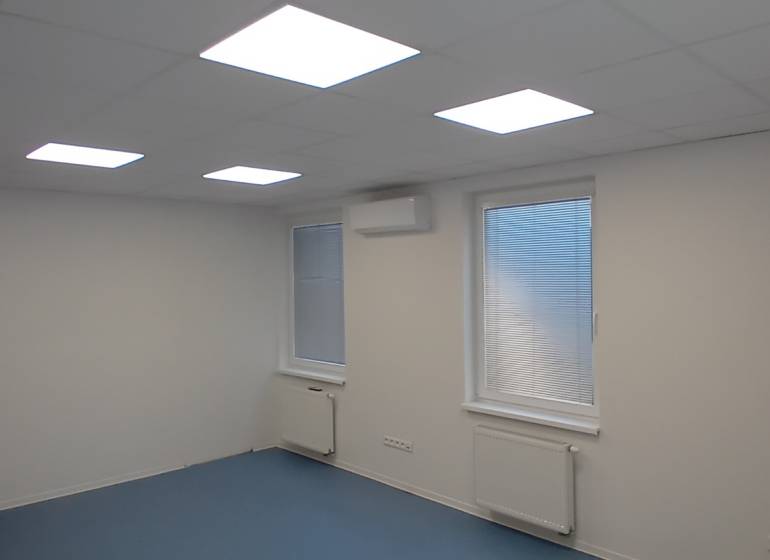 Prenájom klimatizovanej kancelárie, 24 m² – Trnava, Bulharská ulica - Kancelárie s bielym stropom, modrou podlahou a oknami so žalúziami.