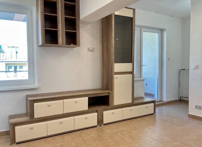 I Predaj Investičného 1-izbového bytu s veľkorysou loggiou  - Obývací priestor v 1-izbovom byte s nábytkom a keramickou podlahou.