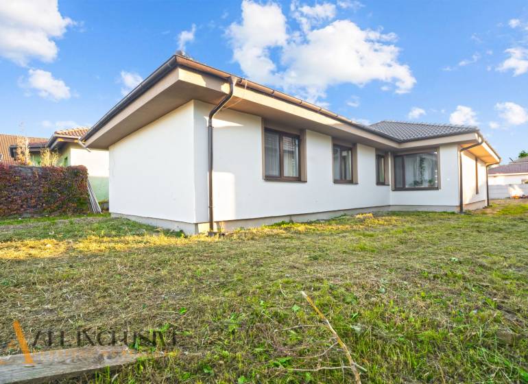REZERVOVANÉ 5-IZBOVÝ RODINNÝ DOM VO VEĽKEJ PAKE - Rodinný dom vo Veľkej Pake s upraveným trávnikom a svetlou fasádou.