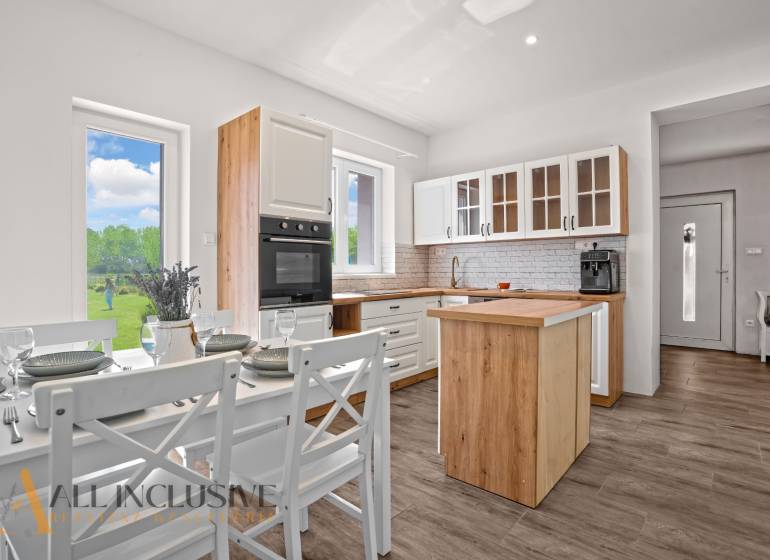 REZERVOVANÉ 3-IZBOVÝ RODINNÝ DOM V OBCI BALOŇ - Kuchyňa v rodinnom dome s dreveným dekorom a jedálenským stolom.