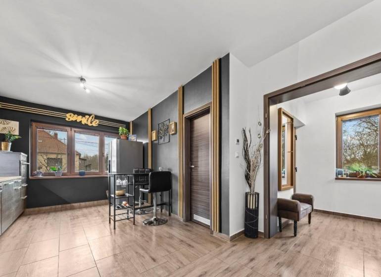 Na predaj 5-izb. rodinný dom na 50-á pozemku, Sap - Kuchyňa v rodinnom dome s podlahou s dreveným dekorom a veľkými oknami.