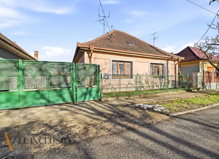 Na predaj 3-izb.rod.dom s dvojgarážou,Vojka nad Dunajom - Rodinný dom vo Vojke nad Dunajom so zelenou bránou a murovaným plotom.