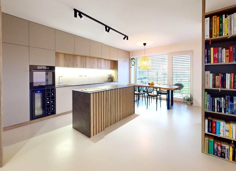 Novozariadený rodinný dom s veľkými spálňami i šatníkom pri Trenčíne   - Otvorná kuchyňa s jedálenským stolom a knihovničkou v rodinnom dome.