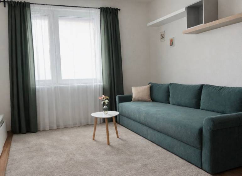 Vkusne zariadený 2i byt na sídlisku WEST,  Galanta - Obývacia izba v 2-izbovom byte so zelenou pohovkou a bielym stolíkom.