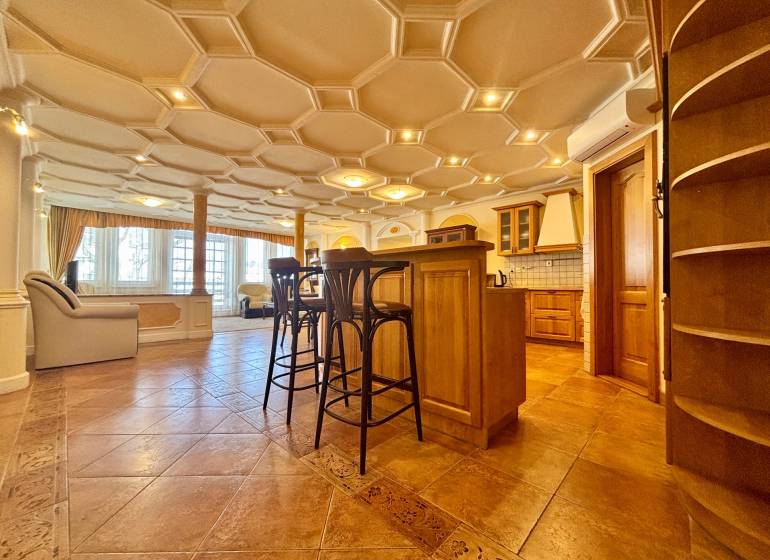 I PRENÁJOM - Priestranný 4 izbový byt na Zámockej ulici, BA - Interiér 4-izbového bytu s ozdobným stropom, podlaha s dreveným dekorom, kuchynským ostrovom a stoličkami.