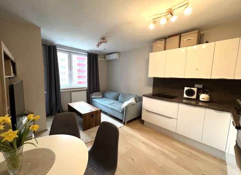 REZERVOVANÉ-PREDAJ 2 izbový byt s garážou v skvelej lokalite v Ružinov - Kuchyňa a obývačka v 2-izbovom byte s podlahou s dreveným dekorom.