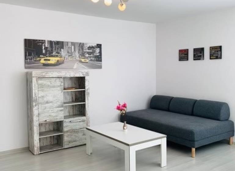 Na predaj 2-i byt s terasou pri Bratislavskom hrade - Obývačka na ulici Palisády. Svetlá 2-izbový byt so sedačkou a stolíkom.