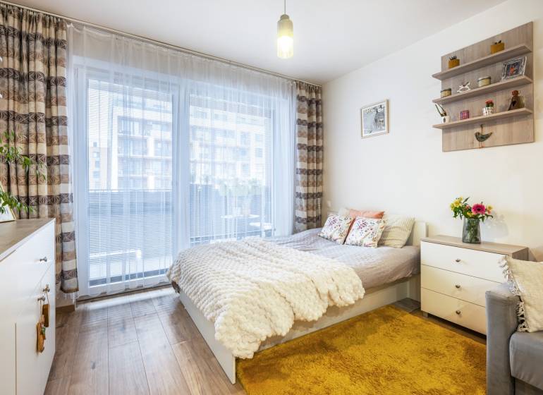 Prenájom 1-izbového bytu, Béžová, Béžová, Petržalka - REZERVOVANÉ - Svetlý 1-izbový byt s posteľou, kobercom a podlahou s dreveným dekorom.