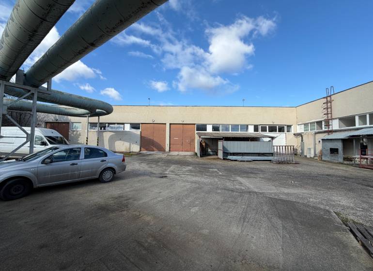 Predám skladovú halu v Nových Zámkoch - Sklady a haly v Nových Zámkoch na ulici Nové Zámky s priemyselným komplexom a autami.