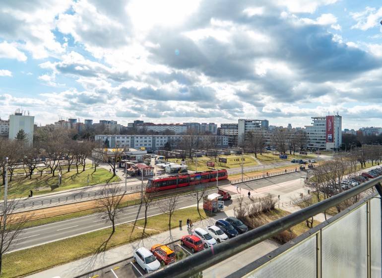 Komfortný 1,5-izbový byt s balkónom v Ružinove na predaj - Výhľad na rušnú ulicu v Bratislave - Ružinov, Súmračná, s električkou a parkom.