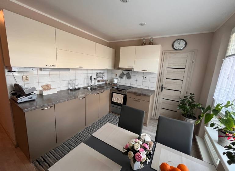 Na predaj  3-izbový byt v meste Rajec  - Kuchyňa v 3-izbovom byte so svetlými skrinkami a jedálenským stolom.