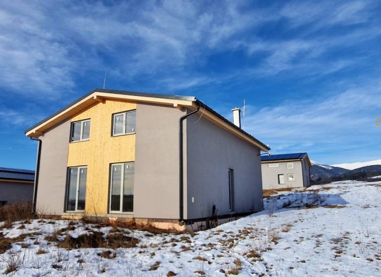 Únik z mesta, kde sa moderná architektúra stretáva s divokou prírodou? - Chata v Dolnej Lehote s dreveným obkladom, zasnežená krajina a hory na obzore.