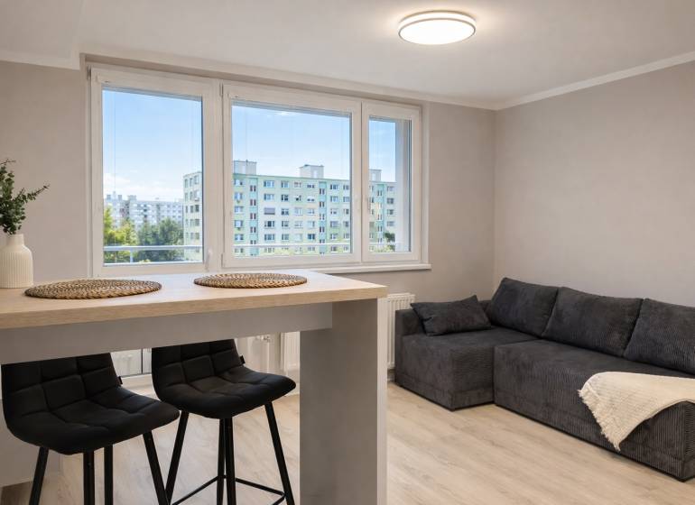 Prenájom 2-izbový byt s loggiou, 54m2, Bratislava-Petržalka - Obývacia izba v 2-izbovom byte s pohovkou, barovým stolom a stoličkami.