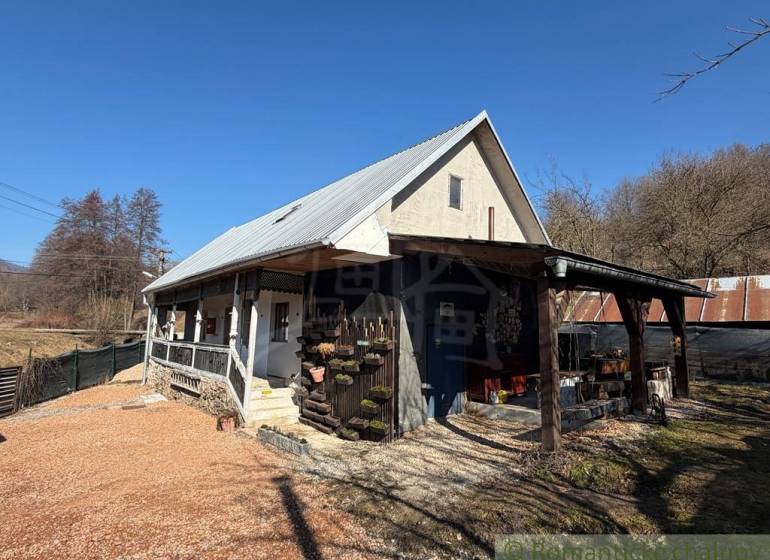 Štýlová chalupa v horskej dedinke Ratkovské Bystré - Rodinný dom v Ratkovskom Bystrom so sedlovou strechou a drevenou verandou.