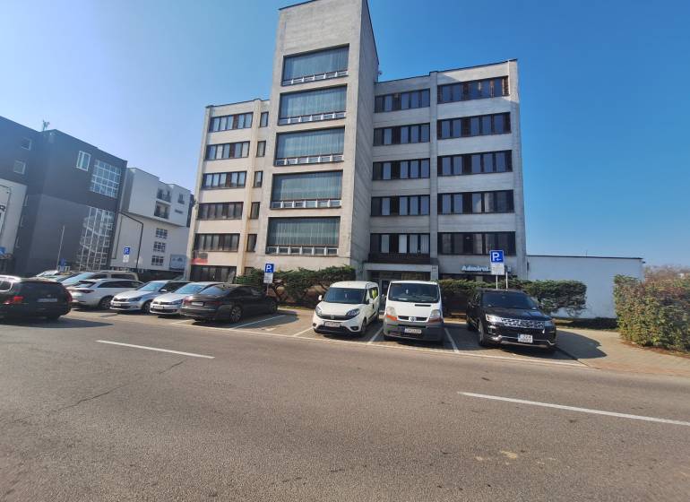 Ubytovanie pre zamestnancov, 64 m2, Tulská ul., Zvolen - Západ - Budova na Tulskiej ulici vo Zvolene, pred ktorou parkujú autá.