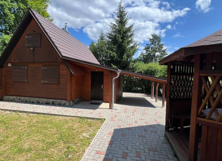 NA PREDAJ Chata na Duchonke- Prašice - Drevená chata v Prašiciach s altánkom, stromami a vydláždeným prístupom.