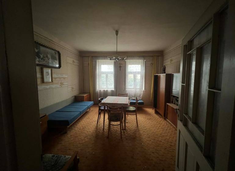 PREDAJ - Rodinný dom na rekonštrukciu s veľkým pozemkom – Kuraľany - Obývacia izba v rodinnom dome s koberecom a historickým nábytkom.