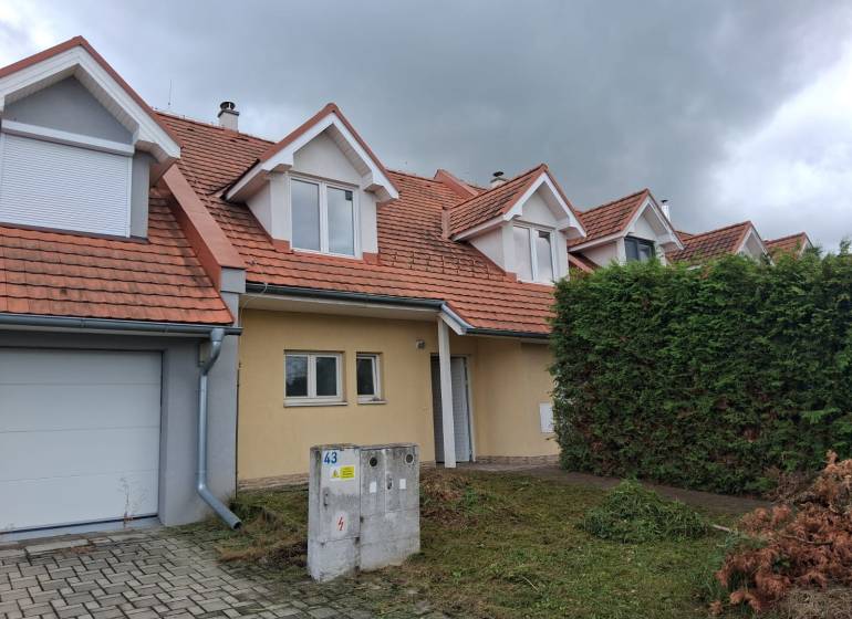 PREDAJ – 4-izbový rodinný dom v radovej zástavbe s garážou - Rodinný dom v Ľubeli s červenou strechou, garážou a udržiavanou záhradou.