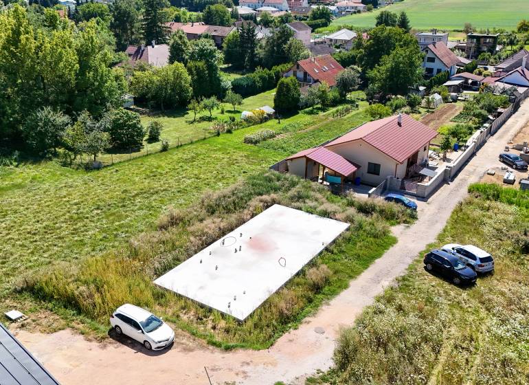 Základová doska na  575 m2 pozemku - Čeľadice  - Letecký pohľad na pozemky v Čeľadiciach vhodné na bývanie, obklopené zeleňou a domami.