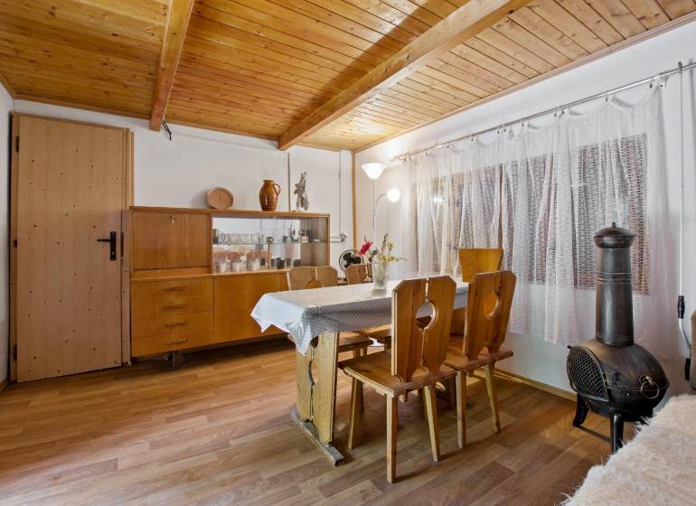 NA PREDAJ CHATA V REKREAČNEJ OBLASTI RUDAVA, OBEC MALÉ LEVÁRE - Interiér chaty s drevenými stropmi, podlahou s dreveným dekorom a starožitným nábytkom.