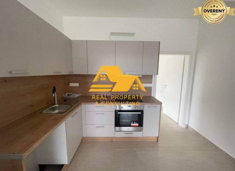 Prenajmem zariadený 3 izbový byt v Nových Zámkoch - Kuchyňa v 3-izbovom byte s dreveným dekorom pracovnej dosky a bielymi skrinkami.