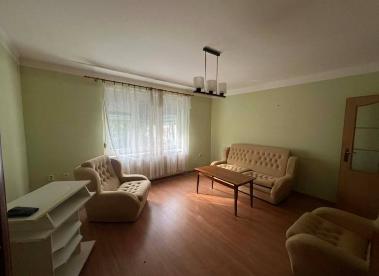 PRENÁJOM - 3-izbového byt vyhľadávaná a kľudná lokalita, Komárno - Obývacia izba v 3-izbovom byte s podlahou s dreveným dekorom a béžovým nábytkom.