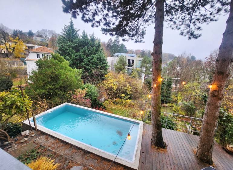 - PRENÁJOM - 2 IZBOVÝ BYT - DOLNÁ UL. - STARÉ MESTO - Výhľad na okolité domy a stromy s bazénom v záhrade na Dolnej ulici.