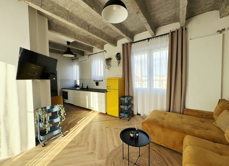 - PRENÁJOM - 3 IZBOVÝ BYT - WILSONOVA UL. - STARÉ MESTO - Obývacia izba v 3-izbovom byte s podlahou s dreveným dekorom a žltou chladničkou.