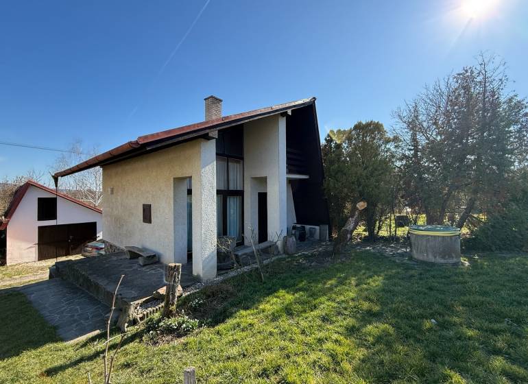PREDAJ - CHATA S VINICOU - ZLATÉ MORAVCE - Chata v Zlatých Moravciach obklopená záhradou a trávnikom pod jasnou oblohou.