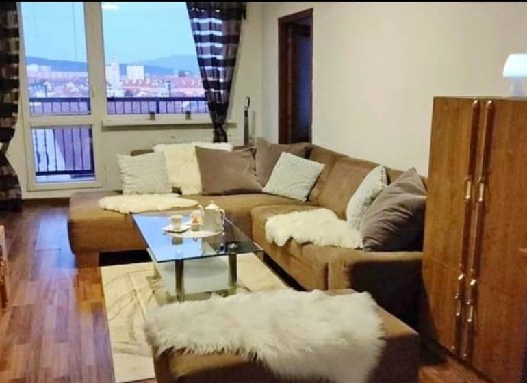 PRENÁJOM - Pekný 3 - izbový byt - Košice - Juh  - Obývacia izba v 3-izbovom byte s pohovkou, skleneným stolom a výhľadom z okna.