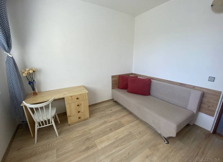 PRENÁJOM - 4 - izbový byt Košice - Západ, Obchodná ulica  - Obývacia izba v 4-izbovom byte so stolom, stoličkou a pohovkou. Podlaha s dreveným dekorom.