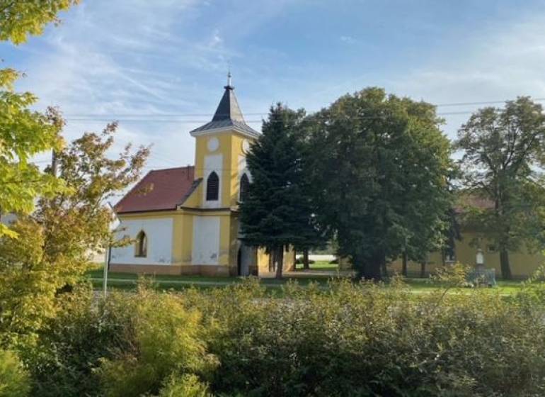 Práznovce – Spoluvlastnícky podiel na ornej pôde - Kostol obklopený zeleňou v Práznovciach na poľnohospodárskych a lesných pozemkoch.