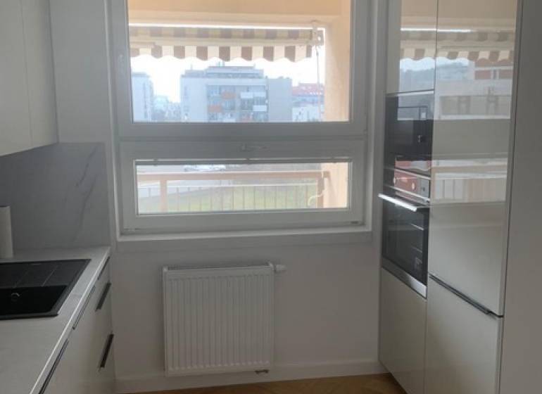 Predaj 2 izbového bytu, Drotárska cesta, Bratislava - Kuchyňa s podlahou s dreveným dekorom v 2-izbovom byte, má moderné spotrebiče.