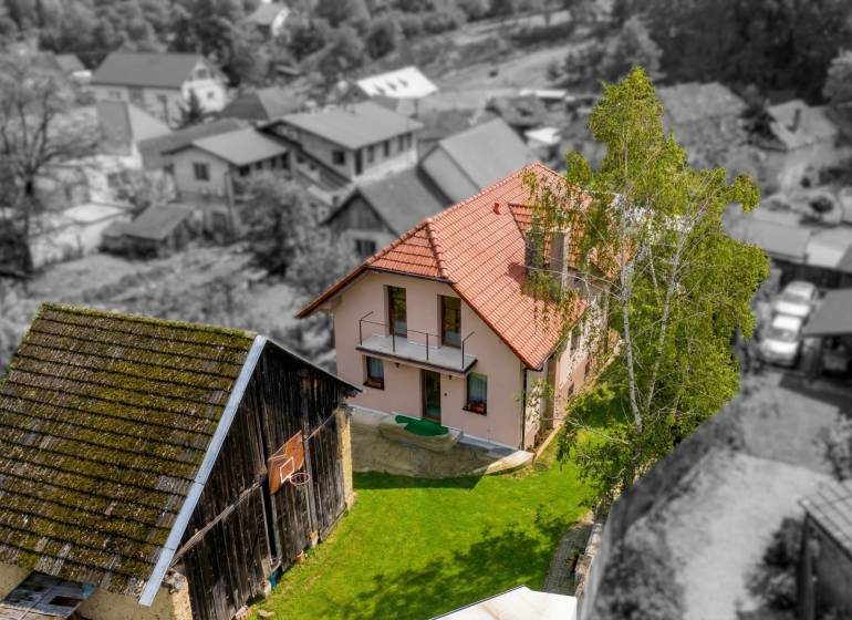 Rodinný dom s veľkým pozemkom a priestorom na podnikanie – T.Jastrabie - Rodinný dom v Trenčianskom Jastrabí s červenou strechou a udržiavanou záhradou.