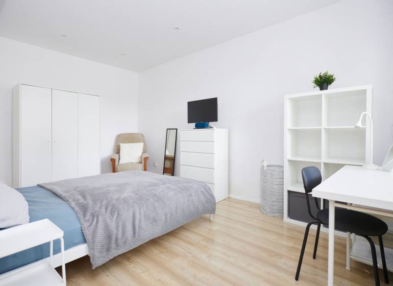 NA PREDAJ,2-IZBOVÝ TEHLOVÝ BYT,KOŠICE-SEVER,LOMNICKÁ UL. - Spálňa v 2-izbovom byte s bielym nábytkom a podlahou s dreveným dekorom.