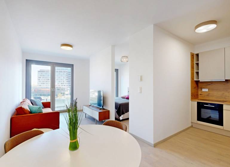 Nový, ešte neobývaný 1,5-izbový byt, parkovanie, Metropolis, Bottova - 2-izbový byt s podlahou s dreveným dekorom, jedálenským stolom a pohovkou.