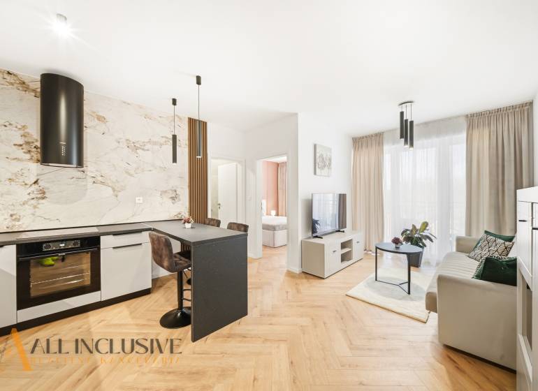 Na prenájom 2-izb. byt s terasou, Dun. Streda -Florida - Obývacia izba a kuchyňa v 4-izbovom byte s podlahou s dreveným dekorom a svetlou výzdobou.