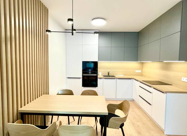 Bory:Na prenájom úplne nový, elegantný 2i byt/eng.text inside - Kuchyňa v 2-izbovom byte s podlahou s dreveným dekorom a jedálenským stolom.