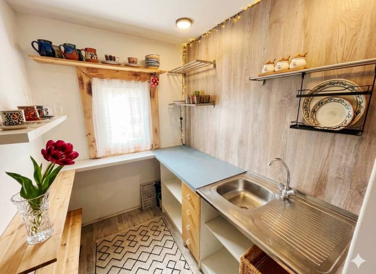 Bývanie v prírode, na dosah mesta, murov. chatka s celoročným využitím - Kuchyňa v rodinnom dome s policami a podlahou s dreveným dekorom.
