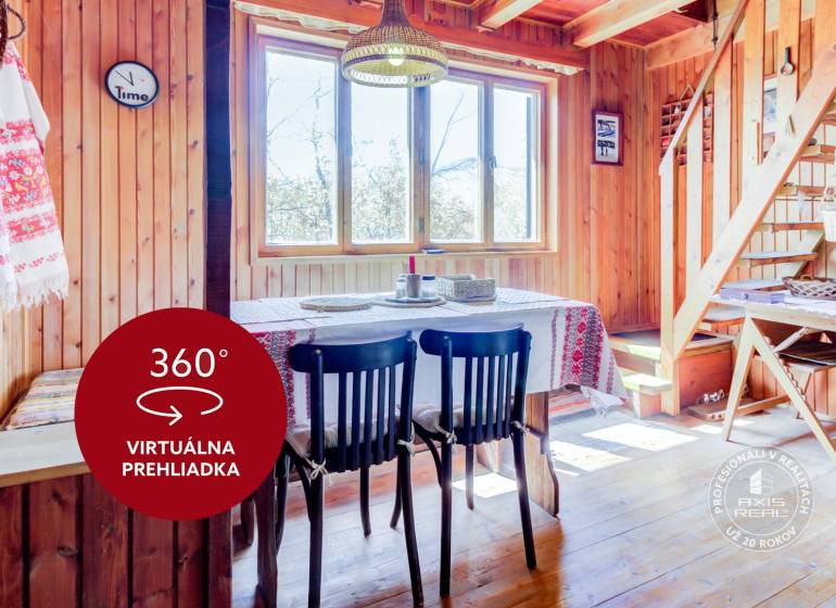Dvojpodlažná chata v krásnom prostredí Buková, okr. Trnava - Drevený interiér chaty s jedálenským stolom, stoličkami, schodmi a tradičnými textíliami.