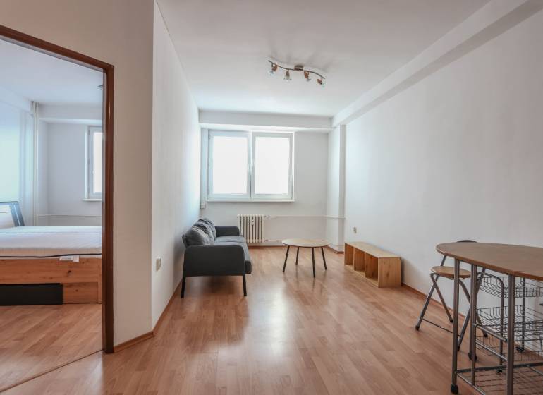 Na prenájom 2 izbový byt v Piešťanoch - Interiér 2-izbového bytu s gaučom, stolíkom a podlahou s dreveným dekorom.